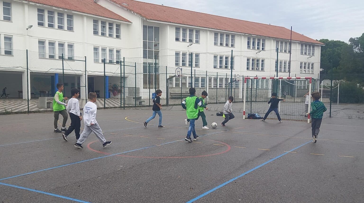 Alunos a jogar futebol no recreio da escola